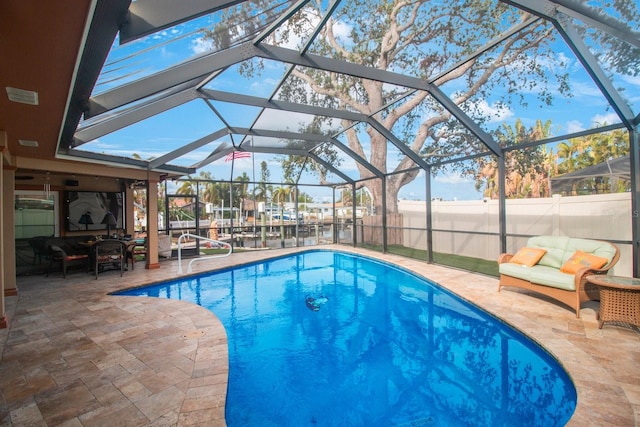 view of swimming pool with a water view, glass enclosure, and a patio area