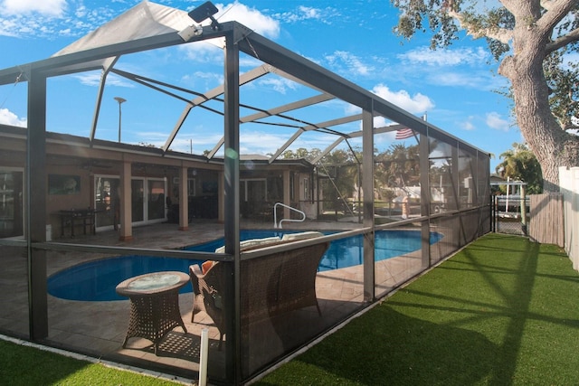 view of pool with a lanai, a patio area, and a yard