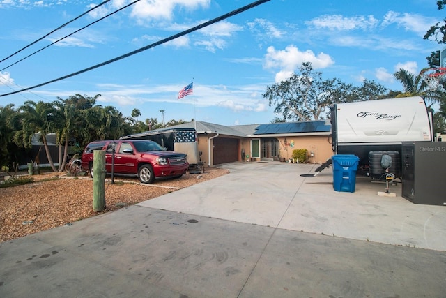 view of front of property with solar panels and a garage