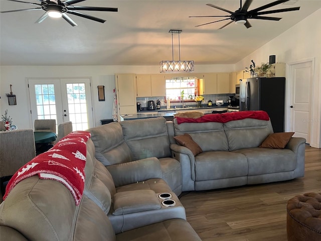 living room featuring lofted ceiling, dark wood-type flooring, a wealth of natural light, and french doors