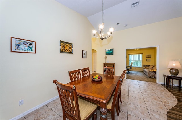 dining room featuring light tile patterned floors, a chandelier, and vaulted ceiling