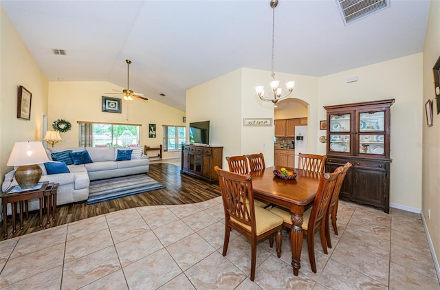 dining room featuring light tile patterned floors, ceiling fan with notable chandelier, and lofted ceiling