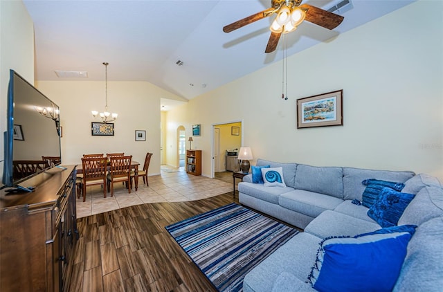 living room with ceiling fan with notable chandelier and lofted ceiling