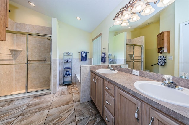 bathroom with walk in shower, vanity, an inviting chandelier, tile walls, and lofted ceiling