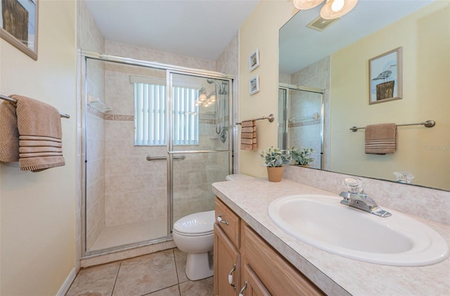 bathroom featuring tile patterned floors, toilet, vanity, and walk in shower