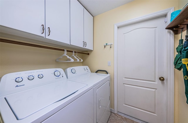 washroom with washing machine and dryer and cabinets