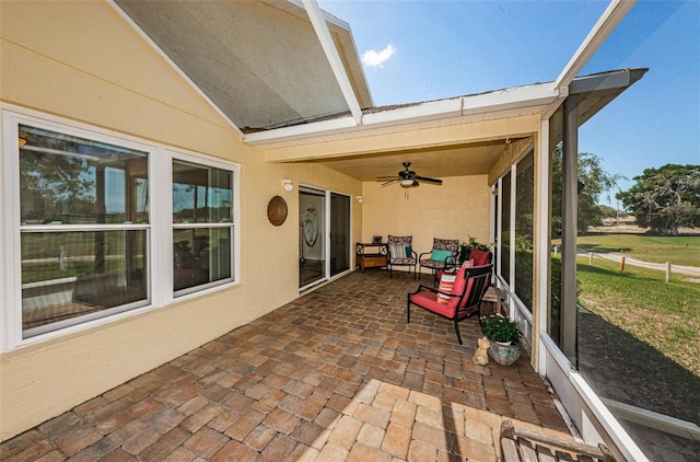 sunroom featuring ceiling fan and vaulted ceiling