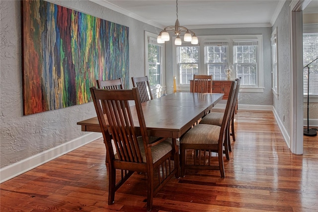 dining area with hardwood / wood-style floors, a chandelier, and ornamental molding