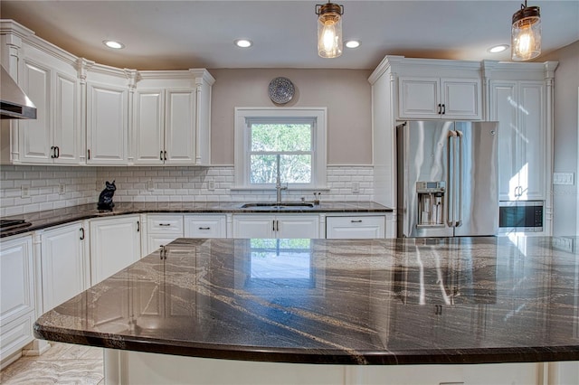 kitchen featuring pendant lighting, stainless steel appliances, white cabinetry, and dark stone counters