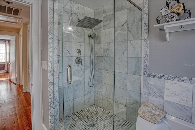 bathroom featuring a shower with shower door and wood-type flooring