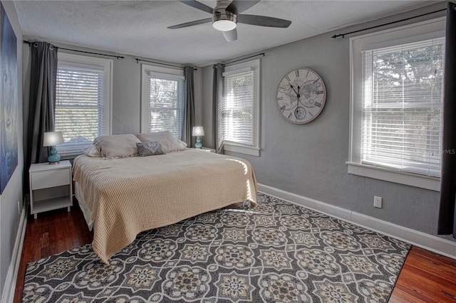 bedroom featuring ceiling fan, hardwood / wood-style floors, and a textured ceiling