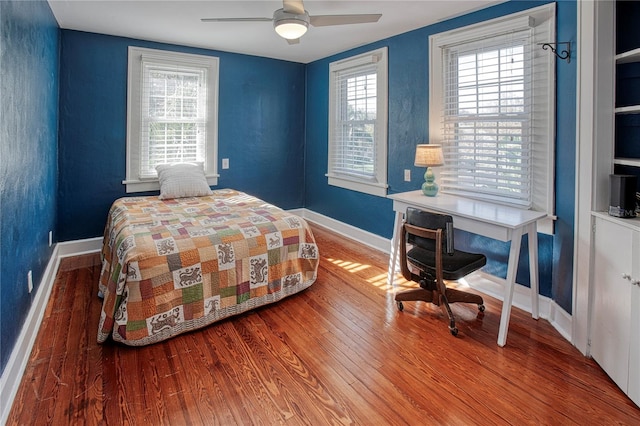 bedroom featuring multiple windows, hardwood / wood-style flooring, and ceiling fan