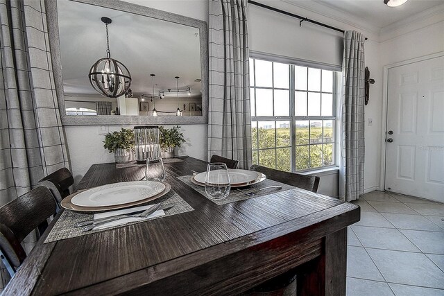 tiled dining room with crown molding, a healthy amount of sunlight, and a chandelier