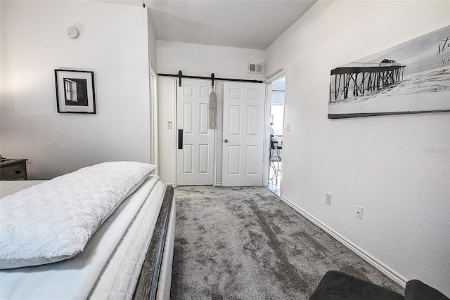 bedroom with a barn door and carpet