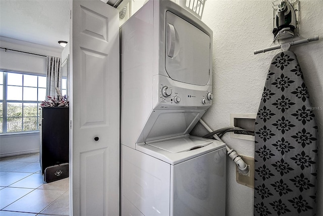 washroom featuring stacked washer / drying machine and light tile patterned floors