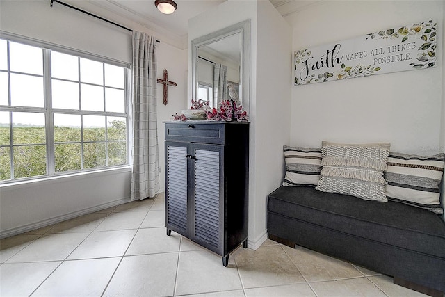 interior space with ornamental molding and light tile patterned floors