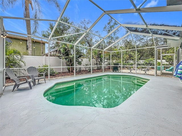 view of swimming pool featuring a lanai and a patio