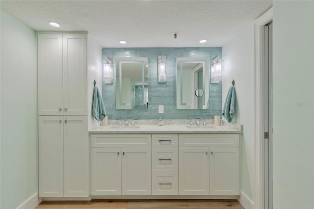 bathroom with vanity, wood-type flooring, and a textured ceiling