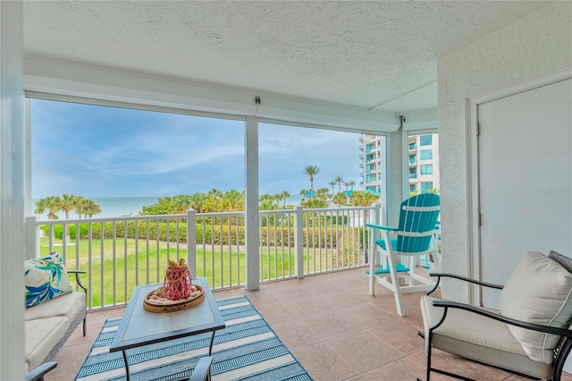 sunroom featuring a water view