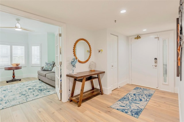 foyer featuring hardwood / wood-style flooring, ceiling fan, and crown molding