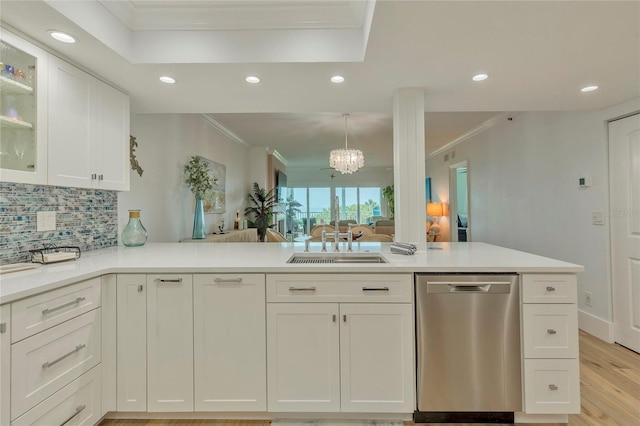 kitchen featuring sink, kitchen peninsula, stainless steel dishwasher, ornamental molding, and white cabinetry