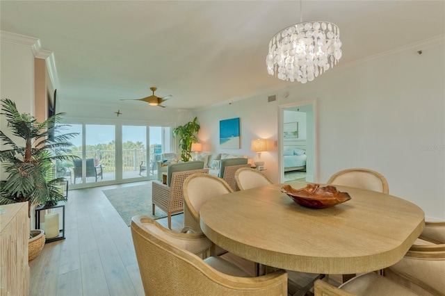 dining room featuring ceiling fan with notable chandelier, light hardwood / wood-style floors, and crown molding