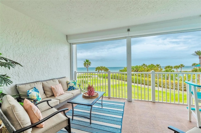 sunroom featuring a water view