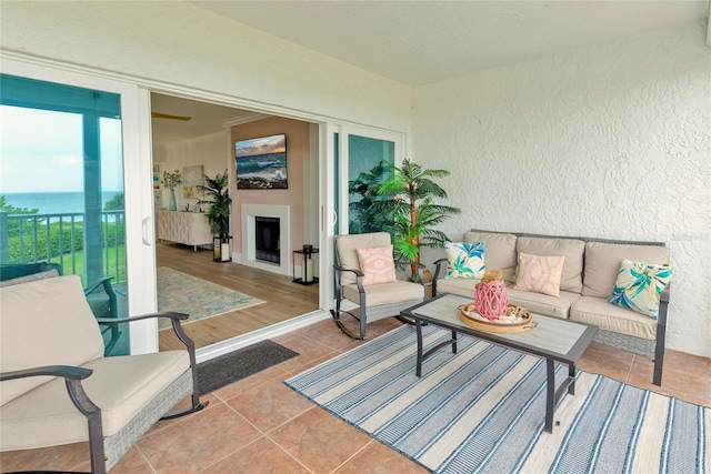 living room featuring a water view and light tile patterned flooring