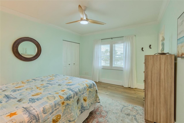 bedroom featuring a closet, ceiling fan, light hardwood / wood-style flooring, and ornamental molding