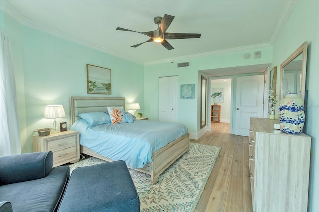 bedroom with crown molding, ceiling fan, a closet, and light hardwood / wood-style floors