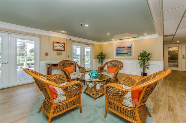 sitting room featuring crown molding, french doors, and light hardwood / wood-style flooring