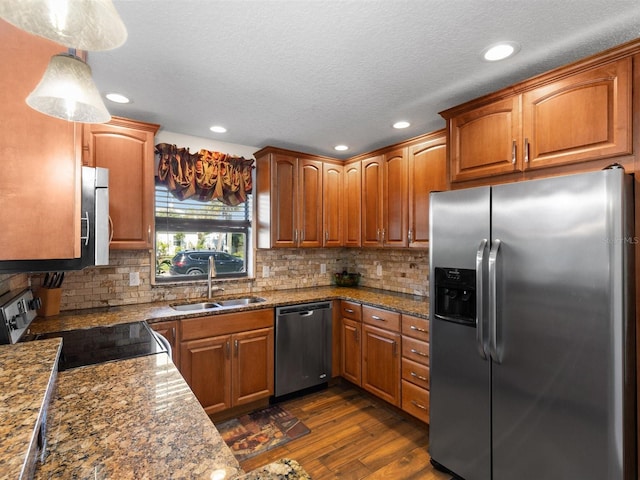 kitchen with stainless steel appliances, hanging light fixtures, dark hardwood / wood-style floors, sink, and tasteful backsplash