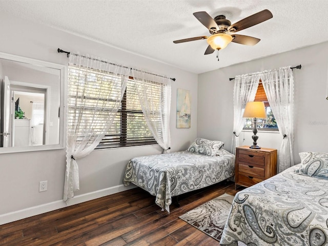 bedroom featuring a textured ceiling, ceiling fan, dark hardwood / wood-style floors, and multiple windows