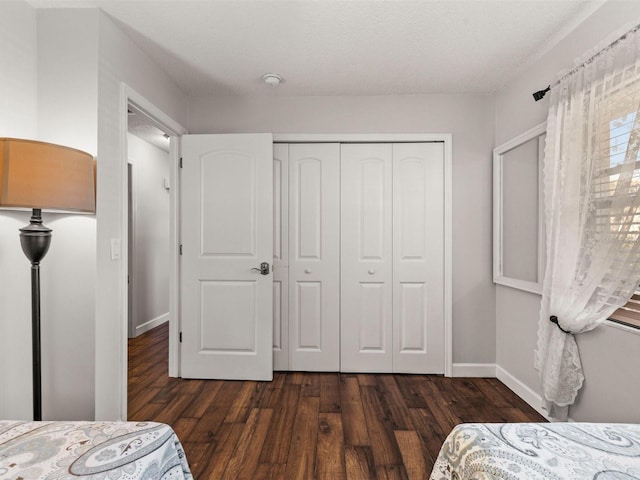 bedroom with dark hardwood / wood-style flooring, a closet, and a textured ceiling