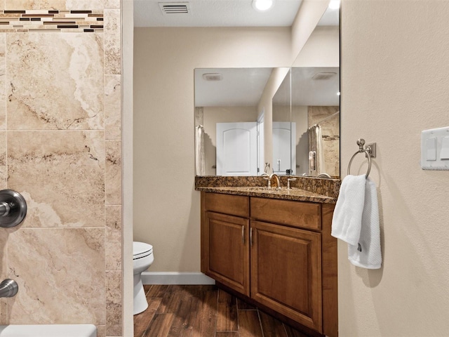 bathroom with walk in shower, vanity, and toilet