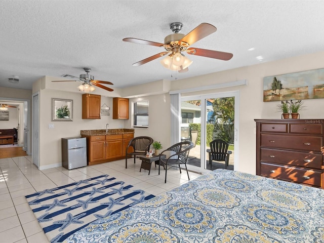 bedroom with sink, a textured ceiling, access to outside, light tile patterned flooring, and ceiling fan