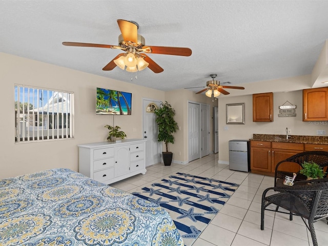 tiled bedroom featuring sink, a closet, ceiling fan, and a textured ceiling