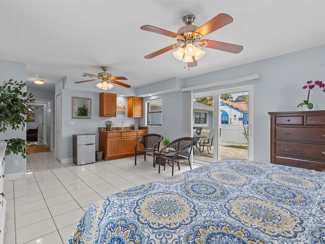 bedroom with a textured ceiling, white fridge, light tile patterned floors, ceiling fan, and sink