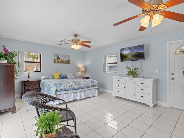 tiled bedroom featuring a textured ceiling and ceiling fan