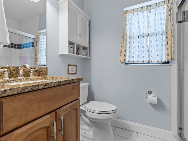 bathroom featuring toilet, a shower with door, vanity, and tile patterned floors