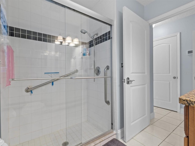 bathroom featuring tile patterned flooring, a shower with door, and vanity