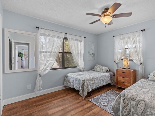 bedroom with dark hardwood / wood-style flooring, a textured ceiling, and ceiling fan