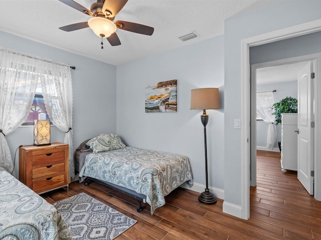 bedroom with dark hardwood / wood-style flooring and ceiling fan