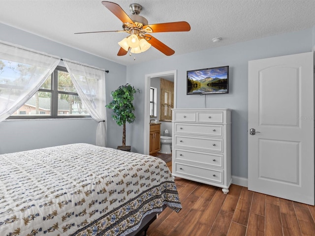 bedroom with a textured ceiling, ceiling fan, and connected bathroom