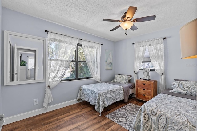 709 Mandalay Ave, Clearwater Beach, FL 33767 - bedroom with multiple windows, wood finished floors, a textured ceiling, baseboards, and ceiling fan