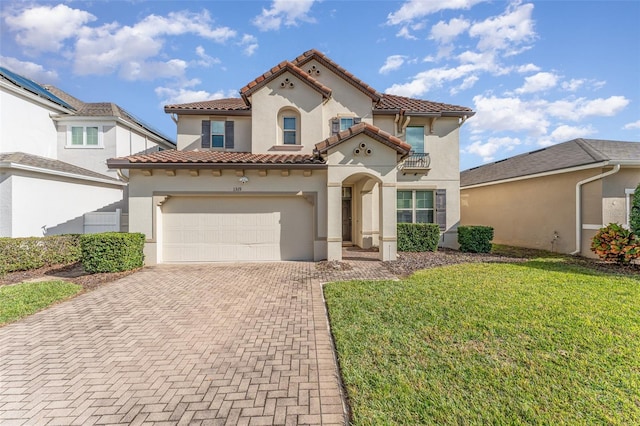 mediterranean / spanish home with a front yard and a garage