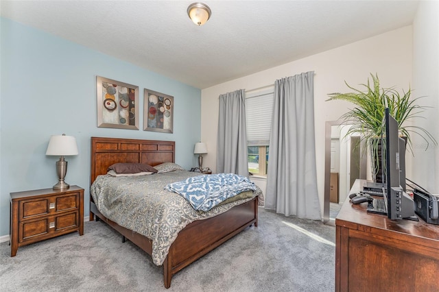 bedroom with light colored carpet and a textured ceiling