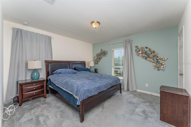 bedroom with a textured ceiling and light carpet