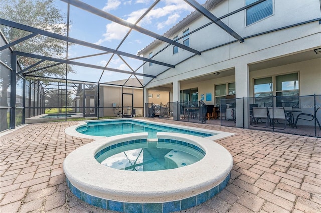 view of pool featuring a lanai, a patio area, and an in ground hot tub