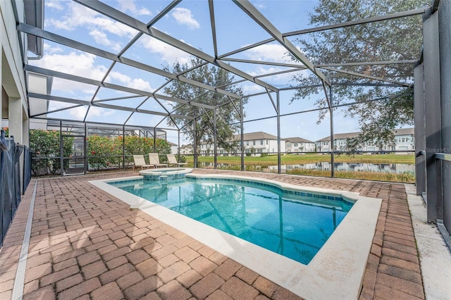 view of pool with an in ground hot tub, a water view, a patio area, and a lanai